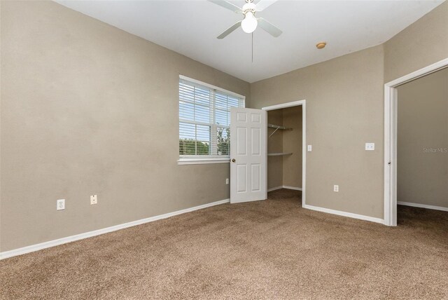 6611 Time Square Ave Unit 103, Orlando, FL 32835 - unfurnished bedroom with carpet floors, a spacious closet, baseboards, a closet, and ceiling fan