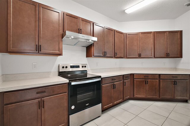 7054 Cruz Ct, Lakeland, FL 33813 - kitchen featuring stainless steel range with electric stovetop, under cabinet range hood, light countertops, and light tile patterned flooring