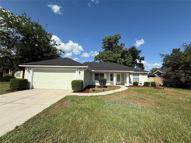 ranch-style house with a garage, concrete driveway, and a porch