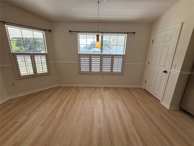 unfurnished dining area featuring light wood-style flooring and baseboards