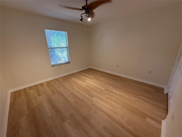 unfurnished room featuring light wood-style flooring, a ceiling fan, and baseboards