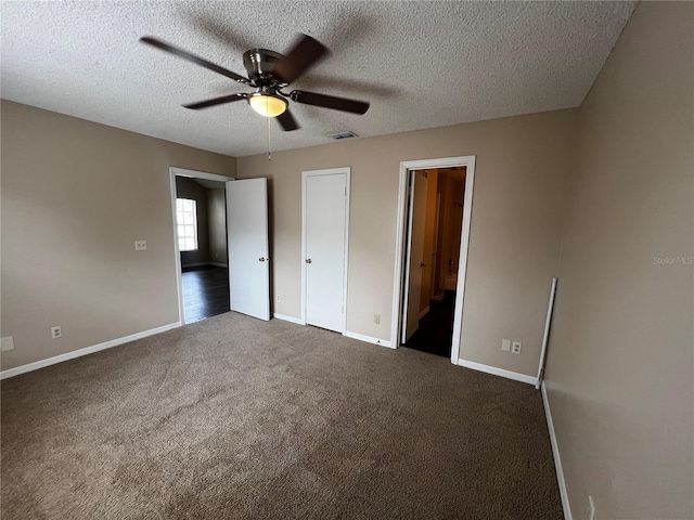 1089 S Hiawassee Rd Unit 323, Orlando, FL 32835 - unfurnished bedroom with dark carpet, baseboards, a textured ceiling, ensuite bath, and ceiling fan