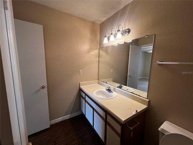 1089 S Hiawassee Rd Unit 323, Orlando, FL 32835 - bathroom with wood finished floors, toilet, a textured wall, vanity, and baseboards