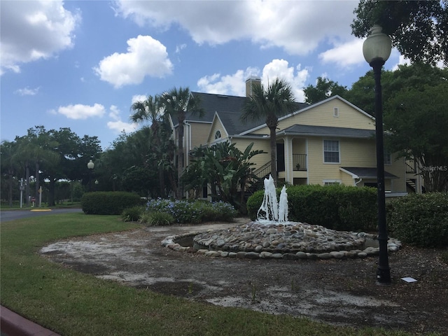1089 S Hiawassee Rd Unit 323, Orlando, FL 32835 - view of home's exterior featuring a chimney and a lawn