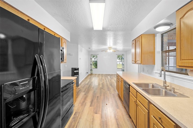 1106 Alpine Ave NW, Palm Bay, FL 32907 - kitchen with black appliances, a sink, a textured ceiling, light wood-style floors, and light countertops