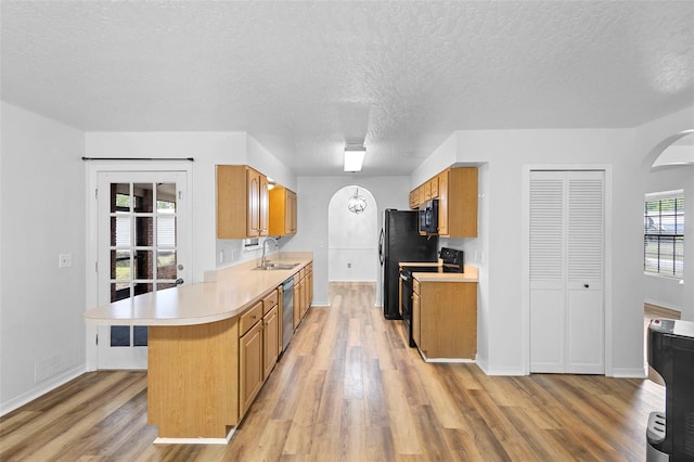 1106 Alpine Ave NW, Palm Bay, FL 32907 - kitchen with black appliances, light countertops, a sink, light wood-type flooring, and a textured ceiling