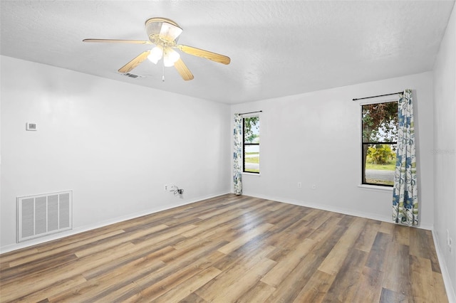 1106 Alpine Ave NW, Palm Bay, FL 32907 - spare room featuring healthy amount of natural light, wood finished floors, ceiling fan, baseboards, and a textured ceiling