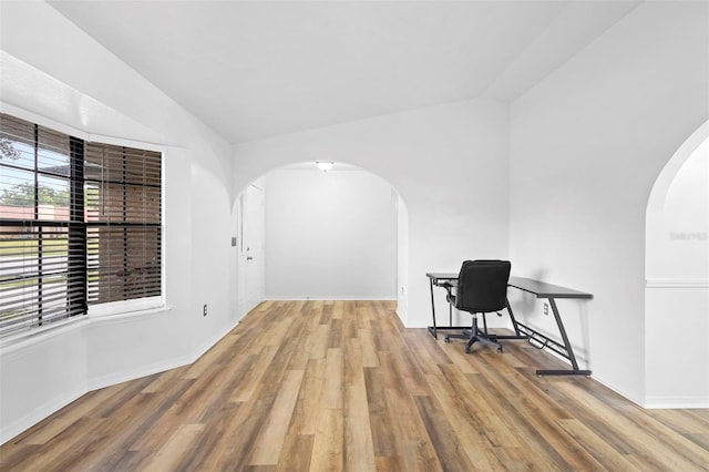 1106 Alpine Ave NW, Palm Bay, FL 32907 - unfurnished office featuring arched walkways, wood finished floors, baseboards, and lofted ceiling