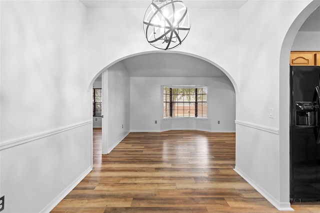 1106 Alpine Ave NW, Palm Bay, FL 32907 - unfurnished dining area with wood finished floors, arched walkways, and baseboards