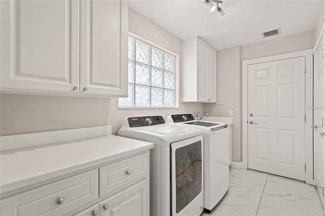 11863 Delfina Ln, Orlando, FL 32827 - washroom featuring cabinet space, washing machine and clothes dryer, and light marble finish floors
