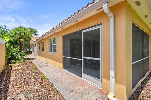 11863 Delfina Ln, Orlando, FL 32827 - view of side of home with stucco siding, a tiled roof, and a patio area