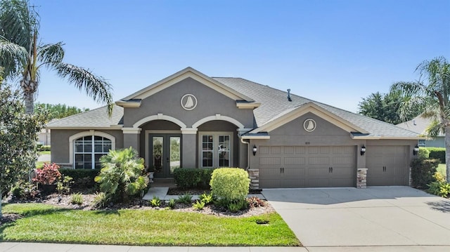8721 Crystal Creek Ct, Land O Lakes, FL 34638 - view of front of home featuring stucco siding, french doors, a garage, and driveway