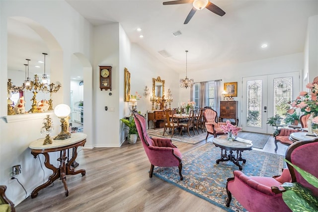 8721 Crystal Creek Ct, Land O Lakes, FL 34638 - living area with arched walkways, wood finished floors, a ceiling fan, vaulted ceiling, and a chandelier