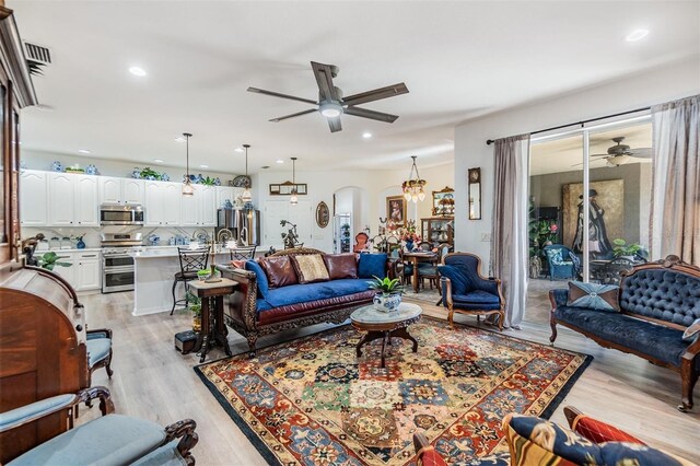 8721 Crystal Creek Ct, Land O Lakes, FL 34638 - living room featuring a ceiling fan, arched walkways, light wood-style flooring, and recessed lighting