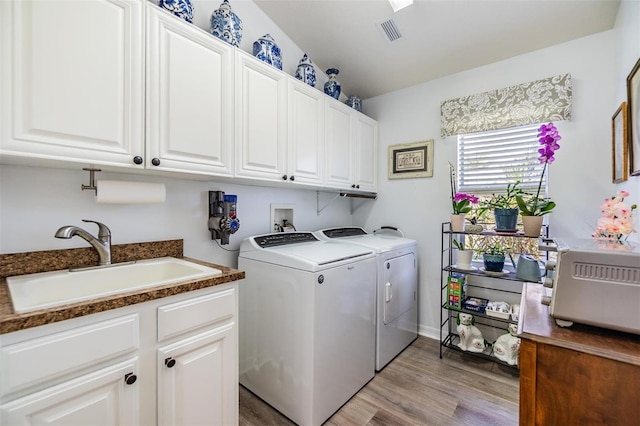 8721 Crystal Creek Ct, Land O Lakes, FL 34638 - laundry area featuring washing machine and clothes dryer, light wood finished floors, and cabinet space
