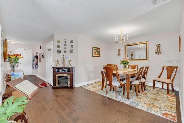 13480 Applerose Ln Unit 19, Orlando, FL 32824 - dining space with a chandelier, wood finished floors, baseboards, a textured ceiling, and a glass covered fireplace