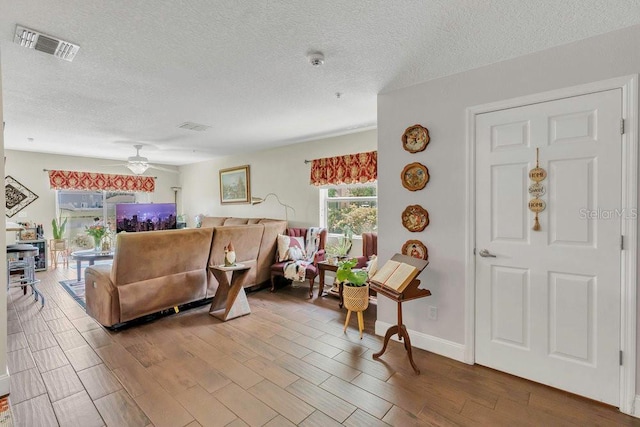 13480 Applerose Ln Unit 19, Orlando, FL 32824 - living area with wood finished floors, a ceiling fan, a textured ceiling, and baseboards