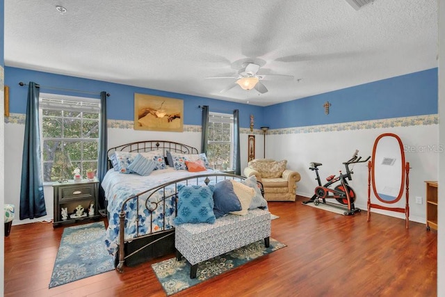 13480 Applerose Ln Unit 19, Orlando, FL 32824 - bedroom with wood finished floors, multiple windows, a textured ceiling, a ceiling fan, and baseboards