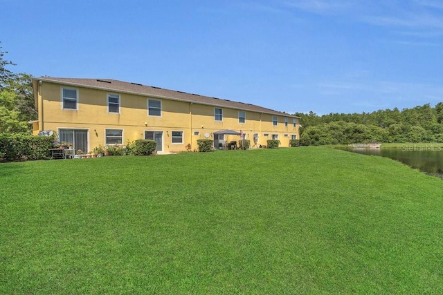 13480 Applerose Ln Unit 19, Orlando, FL 32824 - rear view of property with a yard, stucco siding, and a water view