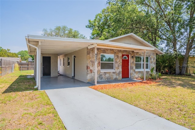 4827 Elese St, Orlando, FL 32811 - view of front of home featuring concrete driveway, a carport, and stone siding