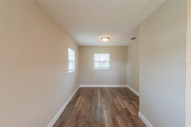 4827 Elese St, Orlando, FL 32811 - empty room with wood finished floors, a textured ceiling, and baseboards