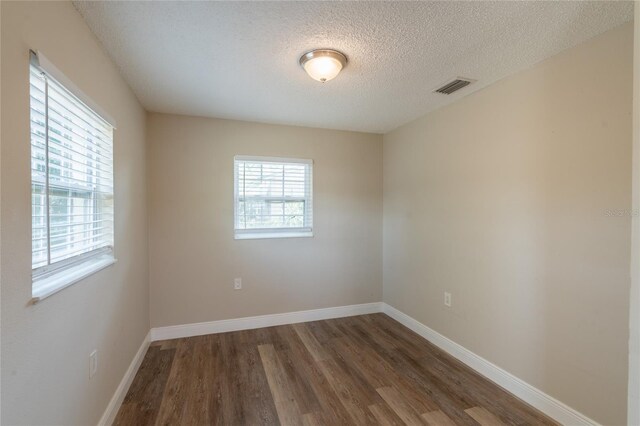 4827 Elese St, Orlando, FL 32811 - unfurnished room with wood finished floors, a textured ceiling, and baseboards
