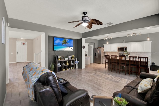 1744 Pine Ridge Dr, Davenport, FL 33896 - living area featuring a ceiling fan, light wood-style floors, and baseboards