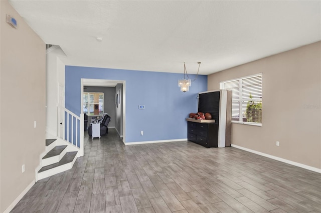 1744 Pine Ridge Dr, Davenport, FL 33896 - living area with wood finished floors, baseboards, stairs, and a chandelier