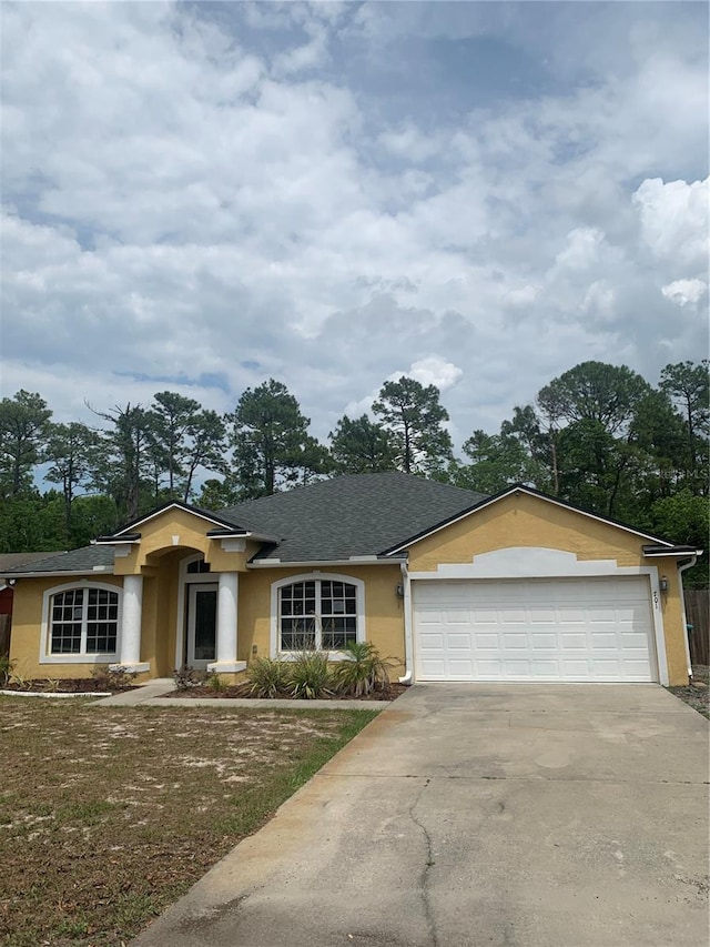 701 Twin Lake Ave, Deltona, FL 32738 - single story home with stucco siding, driveway, a garage, a front lawn, and a shingled roof