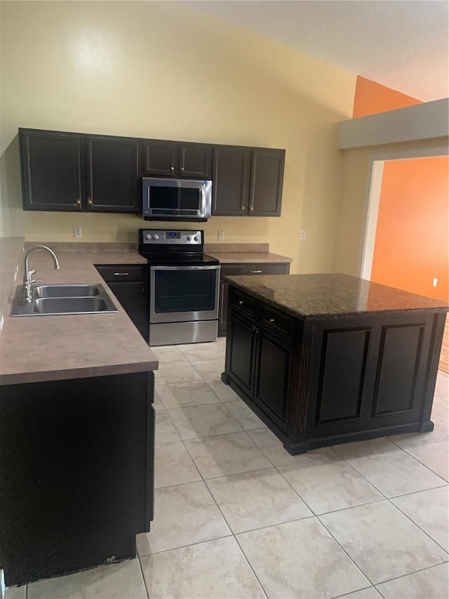 701 Twin Lake Ave, Deltona, FL 32738 - kitchen featuring stainless steel appliances, a sink, dark cabinetry, vaulted ceiling, and a center island