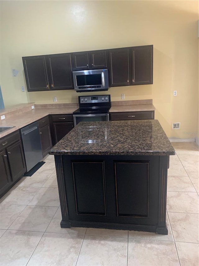 701 Twin Lake Ave, Deltona, FL 32738 - kitchen with stainless steel appliances, dark cabinets, dark stone countertops, and a center island