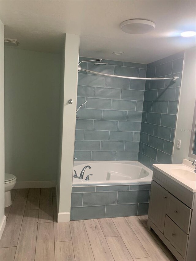 701 Twin Lake Ave, Deltona, FL 32738 - bathroom with wood finished floors, vanity, toilet, and tiled shower / bath