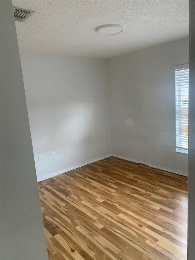 701 Twin Lake Ave, Deltona, FL 32738 - unfurnished room with wood finished floors, a textured ceiling, and baseboards