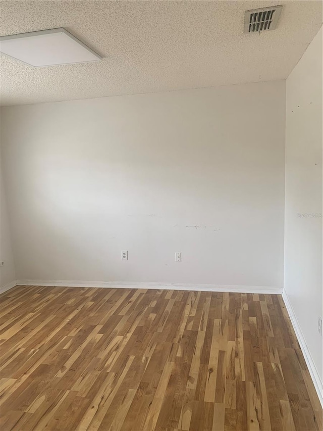 701 Twin Lake Ave, Deltona, FL 32738 - empty room with wood finished floors, a textured ceiling, and baseboards