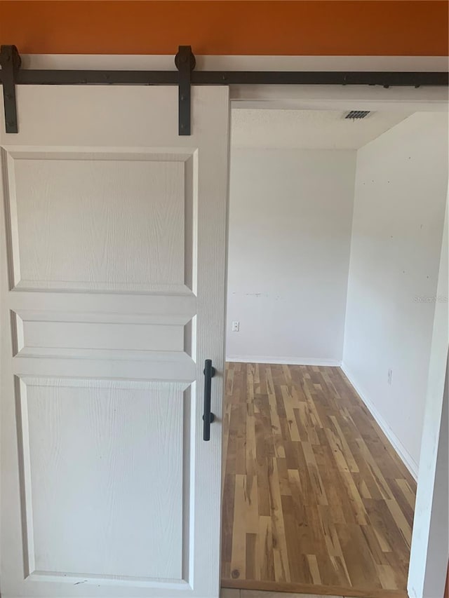 701 Twin Lake Ave, Deltona, FL 32738 - detailed view of wood finished floors, a barn door, and baseboards