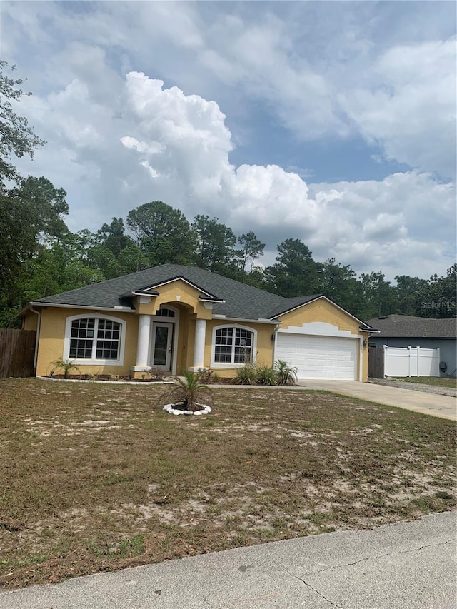 701 Twin Lake Ave, Deltona, FL 32738 - ranch-style house with stucco siding, driveway, a garage, and roof with shingles