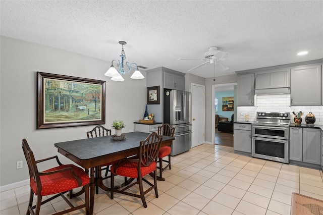 711 Valencia Ct, Winter Garden, FL 34787 - dining room with a ceiling fan, light tile patterned flooring, a chandelier, a textured ceiling, and baseboards
