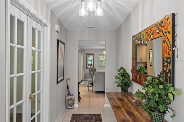 711 Valencia Ct, Winter Garden, FL 34787 - entrance foyer featuring light tile patterned floors, a chandelier, a textured ceiling, and baseboards