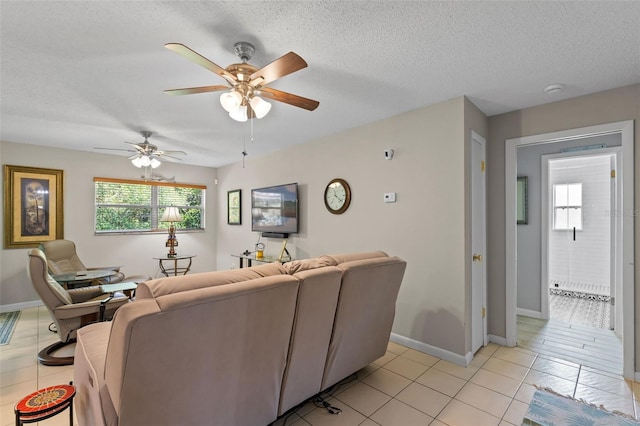 711 Valencia Ct, Winter Garden, FL 34787 - living area with ceiling fan, a textured ceiling, light tile patterned floors, and baseboards