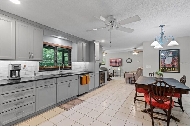 711 Valencia Ct, Winter Garden, FL 34787 - kitchen featuring a sink, stainless steel dishwasher, gray cabinetry, dark countertops, and backsplash