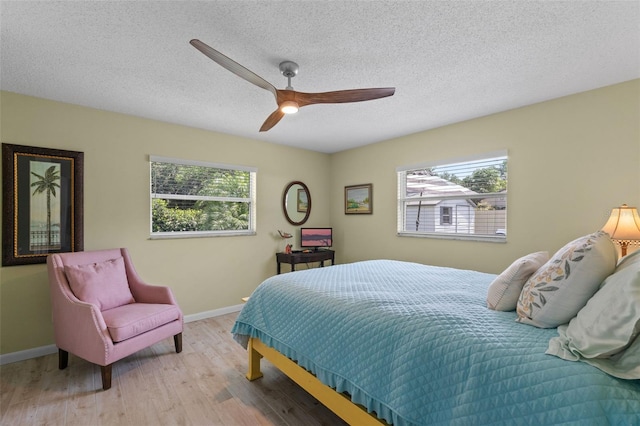 711 Valencia Ct, Winter Garden, FL 34787 - bedroom with wood finished floors, baseboards, ceiling fan, and a textured ceiling