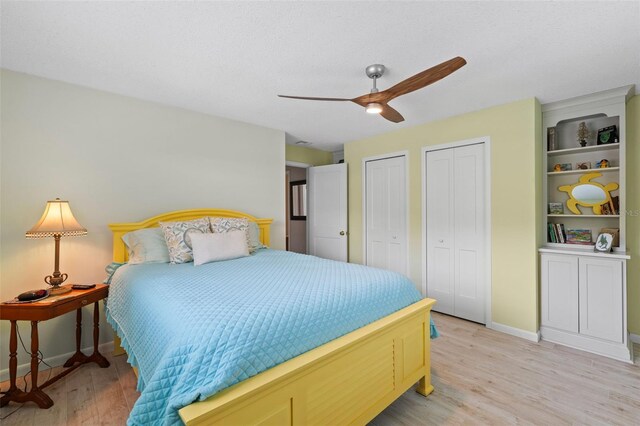 711 Valencia Ct, Winter Garden, FL 34787 - bedroom featuring two closets, light wood-style flooring, baseboards, and a ceiling fan
