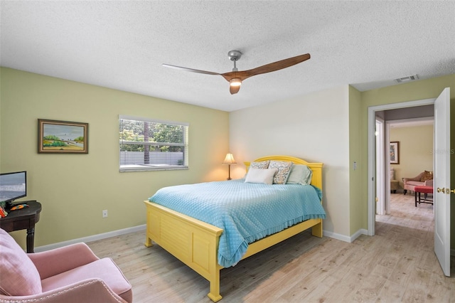 711 Valencia Ct, Winter Garden, FL 34787 - bedroom featuring light wood-type flooring, baseboards, a textured ceiling, and a ceiling fan