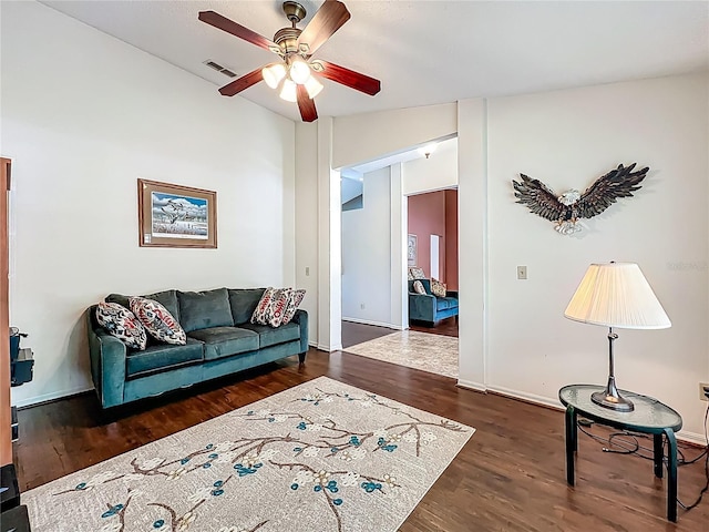 living area featuring wood finished floors, ceiling fan, and baseboards