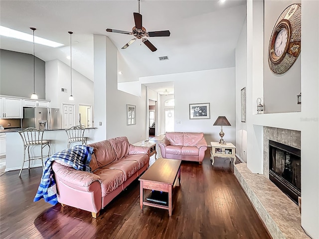 living area featuring ceiling fan, high vaulted ceiling, dark wood-style flooring, and a fireplace