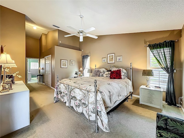bedroom featuring light carpet, a closet, ceiling fan, and high vaulted ceiling