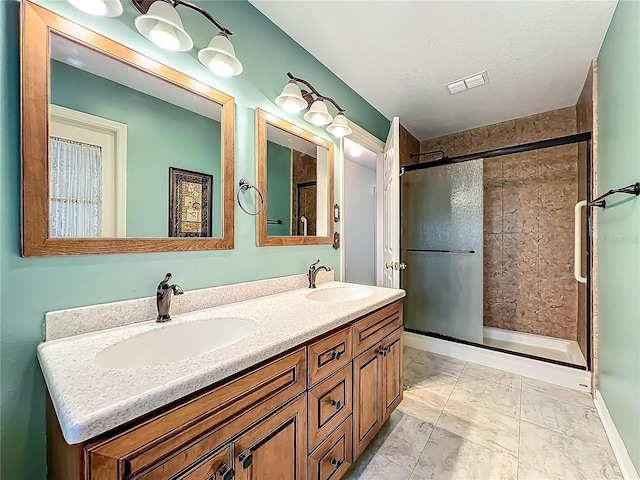 bathroom featuring a shower stall and double vanity