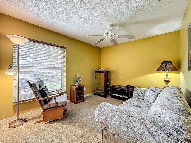 carpeted living room featuring ceiling fan, a textured ceiling, and baseboards