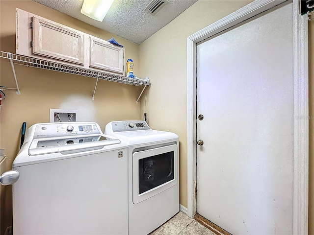 clothes washing area featuring separate washer and dryer and a textured ceiling