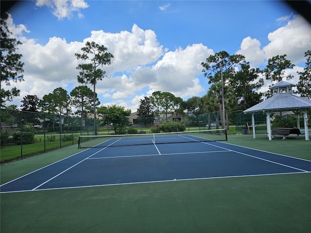 view of tennis court with fence, a gazebo, and community basketball court